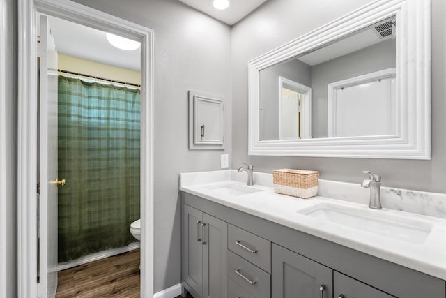 3623 Wells Mark Dr, Humble, TX 77396 - full bath featuring toilet, double vanity, wood finished floors, and a shower with curtain