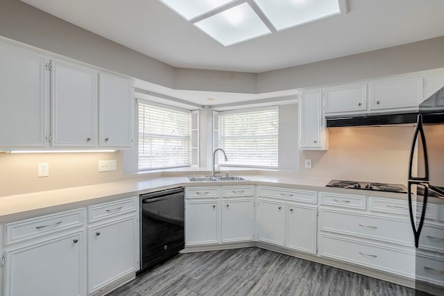 8015 Durklyn Ln, Houston, TX 77070 - kitchen featuring a sink, black appliances, white cabinetry, light countertops, and light wood-style floors