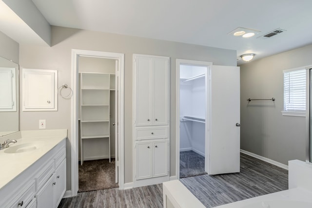 8015 Durklyn Ln, Houston, TX 77070 - full bathroom featuring wood finished floors, vanity, baseboards, and a spacious closet