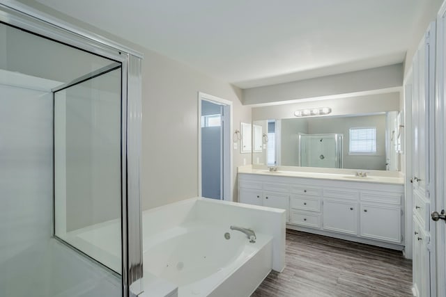 8015 Durklyn Ln, Houston, TX 77070 - bathroom featuring a stall shower, a tub with jets, double vanity, and wood finished floors