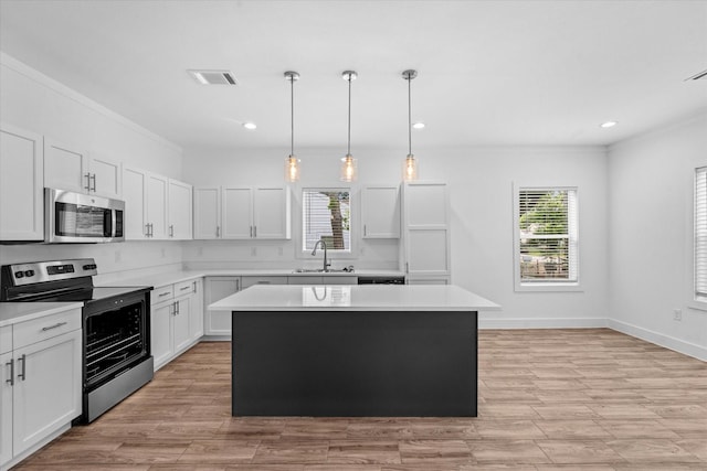 4358 Larkspur St, Houston, TX 77051 - kitchen featuring appliances with stainless steel finishes, a sink, a center island, light countertops, and white cabinets