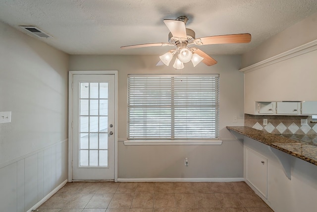 7803 Hurst Forest Dr, Humble, TX 77346 - unfurnished dining area featuring ceiling fan, a textured ceiling, and light tile patterned floors