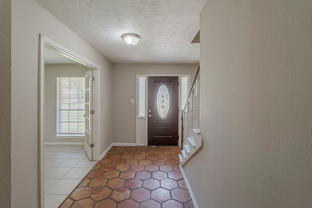 7803 Hurst Forest Dr, Humble, TX 77346 - entrance foyer featuring light tile patterned floors, baseboards, and a textured ceiling