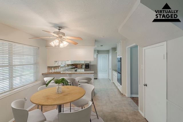 7803 Hurst Forest Dr, Humble, TX 77346 - dining room featuring ceiling fan, a textured ceiling, and baseboards