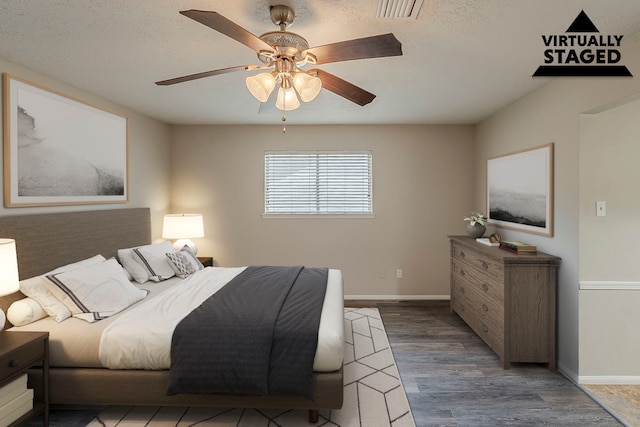 7803 Hurst Forest Dr, Humble, TX 77346 - bedroom featuring wood finished floors, baseboards, ceiling fan, and a textured ceiling