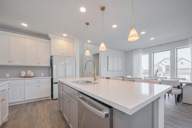 11430 Bush Clover Dr, Cypress, TX 77433 - kitchen with dishwasher, a sink, refrigerator, light countertops, and light wood-style flooring