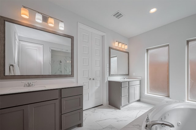 11430 Bush Clover Dr, Cypress, TX 77433 - bathroom featuring marble look tiles, two vanities, a whirlpool tub, and recessed lighting