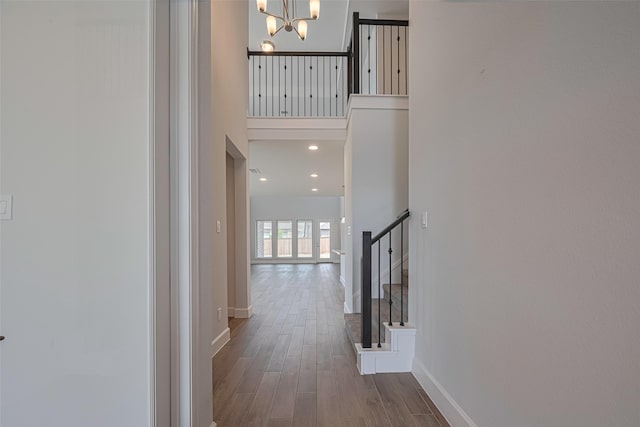 11430 Bush Clover Dr, Cypress, TX 77433 - corridor with stairs, a high ceiling, dark wood-type flooring, a chandelier, and baseboards