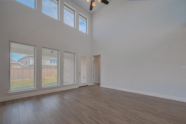 11430 Bush Clover Dr, Cypress, TX 77433 - unfurnished living room with a ceiling fan, a towering ceiling, dark wood finished floors, and baseboards