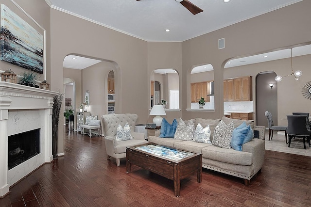 87 S Bluff Creek Cir, The Woodlands, TX 77382 - living room featuring ceiling fan, arched walkways, wood-type flooring, a high end fireplace, and crown molding