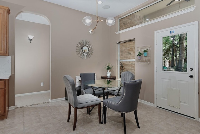 87 S Bluff Creek Cir, The Woodlands, TX 77382 - dining area featuring light tile patterned flooring, baseboards, arched walkways, a chandelier, and a ceiling fan