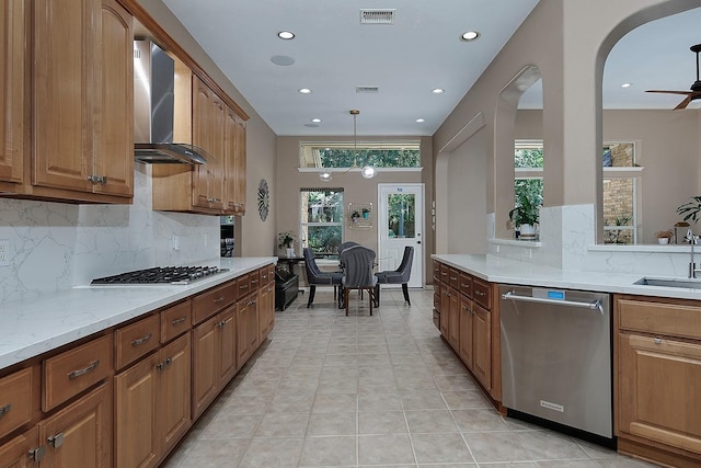 87 S Bluff Creek Cir, The Woodlands, TX 77382 - kitchen featuring stainless steel appliances, wall chimney range hood, tasteful backsplash, recessed lighting, and arched walkways