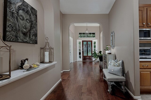 87 S Bluff Creek Cir, The Woodlands, TX 77382 - foyer with arched walkways, dark wood-style flooring, baseboards, and a chandelier