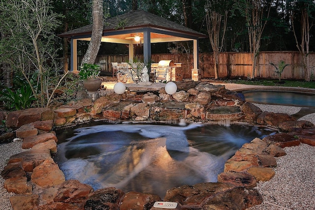 87 S Bluff Creek Cir, The Woodlands, TX 77382 - view of swimming pool with a gazebo, a garden pond, and fence