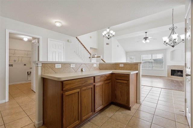 4705 Foster Hill Ct, Houston, TX 77345 - kitchen featuring a chandelier, light tile patterned floors, brown cabinetry, and open floor plan
