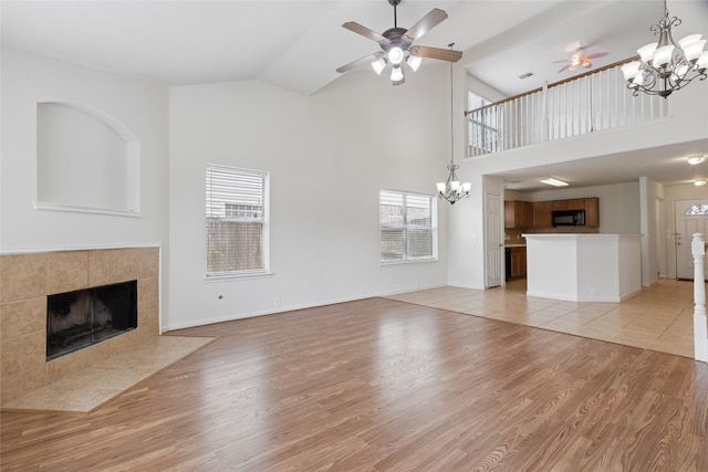 4705 Foster Hill Ct, Houston, TX 77345 - unfurnished living room with a fireplace, a chandelier, a ceiling fan, high vaulted ceiling, and light wood-type flooring