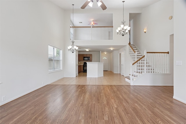 4705 Foster Hill Ct, Houston, TX 77345 - unfurnished living room with ceiling fan, a chandelier, a high ceiling, light wood-style floors, and stairway