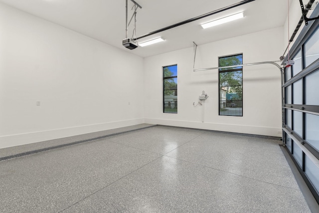 garage featuring a garage door opener and baseboards