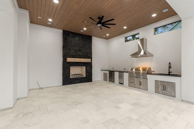 unfurnished living room with a sink, wooden ceiling, ceiling fan, recessed lighting, and a stone fireplace