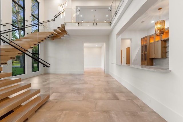 foyer with a high ceiling, stairway, and baseboards