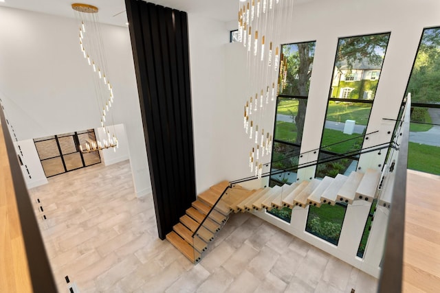 stairs with a chandelier and baseboards