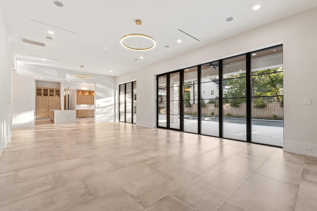 unfurnished living room featuring recessed lighting and baseboards