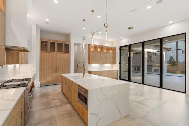 kitchen featuring stainless steel appliances, a sink, modern cabinets, wall chimney range hood, and recessed lighting