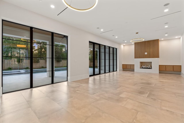unfurnished living room with recessed lighting, a fireplace, and baseboards