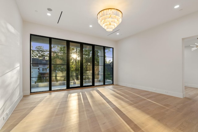 unfurnished room with plenty of natural light, light wood-style flooring, recessed lighting, and baseboards