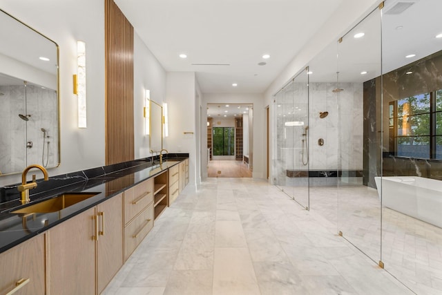 bathroom featuring a shower stall, recessed lighting, a freestanding tub, double vanity, and marble finish floors