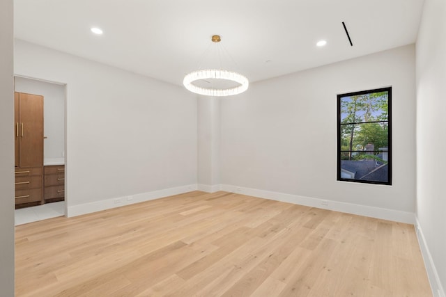 unfurnished room featuring light wood finished floors, baseboards, and recessed lighting