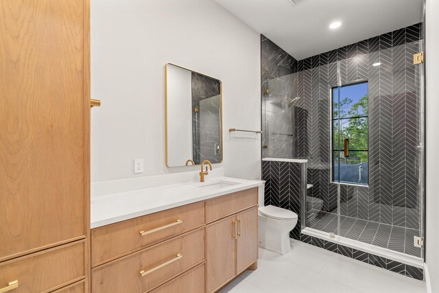 bathroom featuring toilet, a shower stall, vanity, tile patterned floors, and recessed lighting