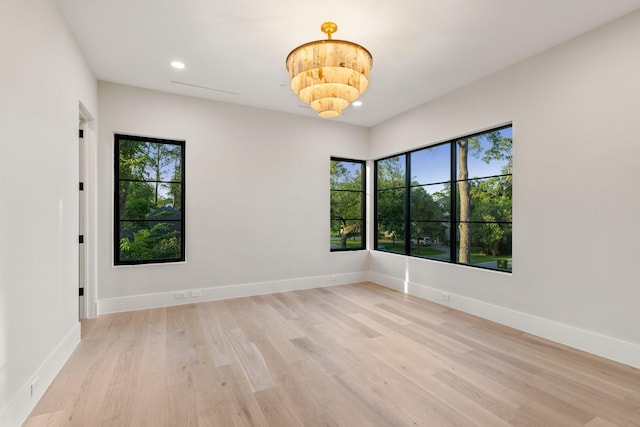 spare room featuring plenty of natural light, light wood-style flooring, recessed lighting, and baseboards