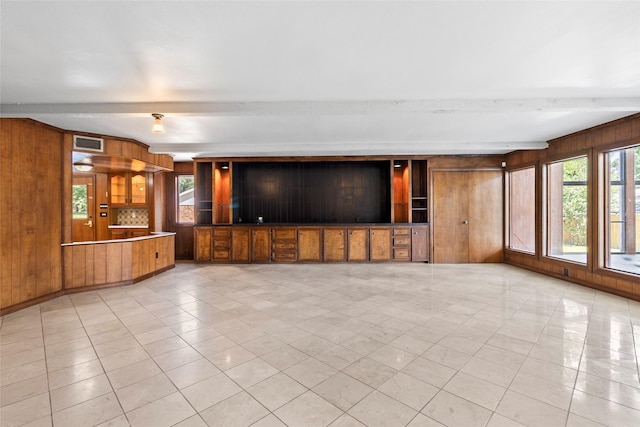 233 Royal Oaks St, Huntsville, TX 77320 - unfurnished living room featuring wooden walls, light tile patterned floors, and beamed ceiling