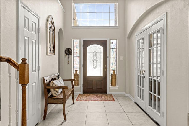 7103 Uther Ct, Spring, TX 77379 - entryway featuring arched walkways, light tile patterned floors, french doors, baseboards, and a towering ceiling