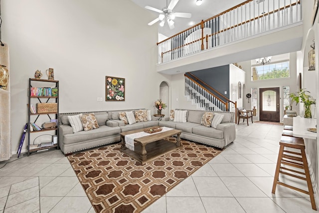 7103 Uther Ct, Spring, TX 77379 - living area with a towering ceiling, stairway, light tile patterned floors, a ceiling fan, and a chandelier