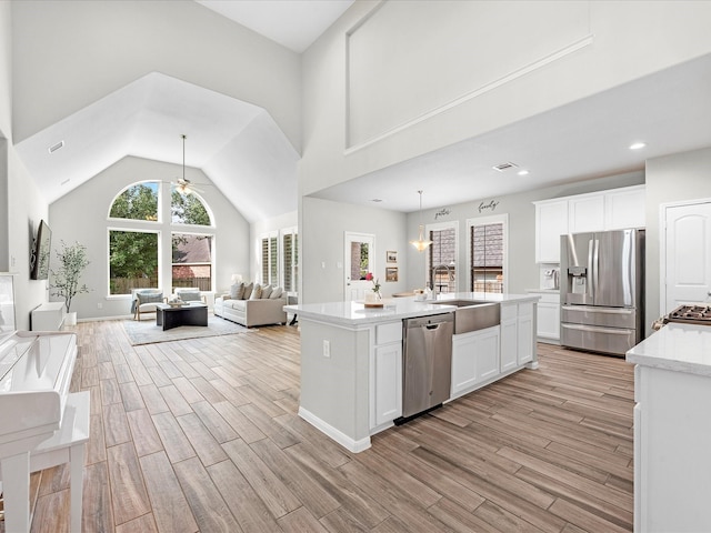 711 Summer Trace Ln, Richmond, TX 77406 - kitchen with a sink, appliances with stainless steel finishes, a ceiling fan, open floor plan, and light wood-style floors