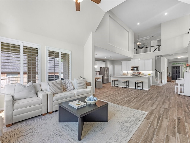 711 Summer Trace Ln, Richmond, TX 77406 - living room featuring high vaulted ceiling, ceiling fan, light wood-type flooring, and baseboards