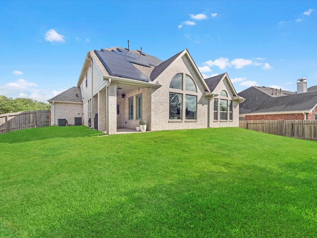 711 Summer Trace Ln, Richmond, TX 77406 - rear view of property featuring roof mounted solar panels, brick siding, central AC, a patio, and a shingled roof