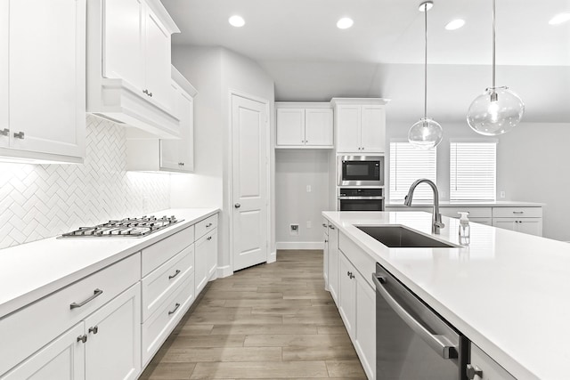 19331 Wild Sabino Way, Tomball, TX 77377 - kitchen featuring a sink, stainless steel appliances, light wood-type flooring, light countertops, and decorative backsplash