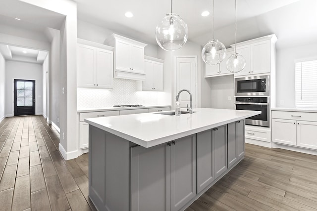 19331 Wild Sabino Way, Tomball, TX 77377 - kitchen with stainless steel oven, a sink, built in microwave, wood finished floors, and stovetop