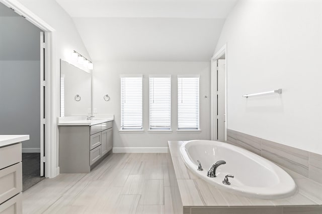 19331 Wild Sabino Way, Tomball, TX 77377 - full bathroom featuring vaulted ceiling, vanity, a bath, and baseboards