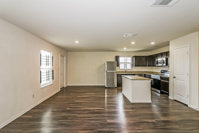 2203 Pearl St, Houston, TX 77029 - kitchen featuring appliances with stainless steel finishes, a center island, recessed lighting, dark wood-style flooring, and baseboards