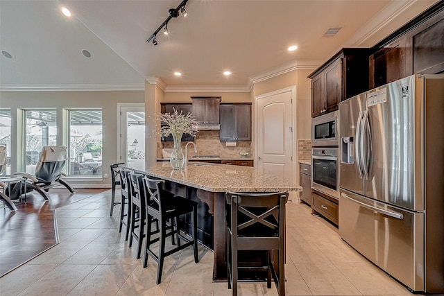 5123 Wheaton Park Dr, Sugar Land, TX 77479 - kitchen with appliances with stainless steel finishes, decorative backsplash, light stone counters, dark brown cabinets, and crown molding