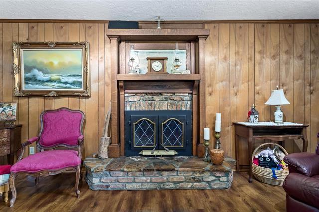 527 E Walton Rd, Lumberton, TX 77657 - living area with wood finished floors, a textured ceiling, and wood walls