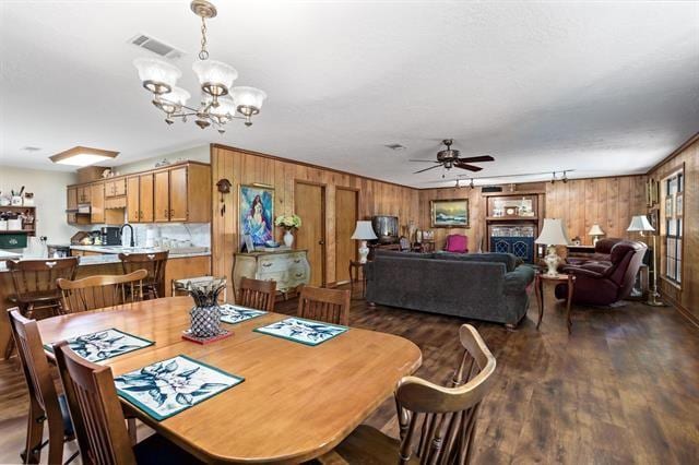 527 E Walton Rd, Lumberton, TX 77657 - dining area featuring wooden walls, dark wood-style floors, a ceiling fan, and a chandelier