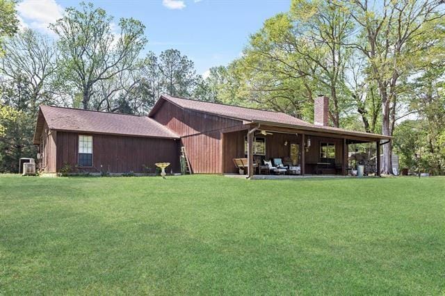 527 E Walton Rd, Lumberton, TX 77657 - back of house with a chimney, a lawn, cooling unit, and a patio