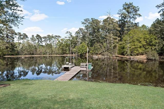 527 E Walton Rd, Lumberton, TX 77657 - dock with a water view, a forest view, and a lawn