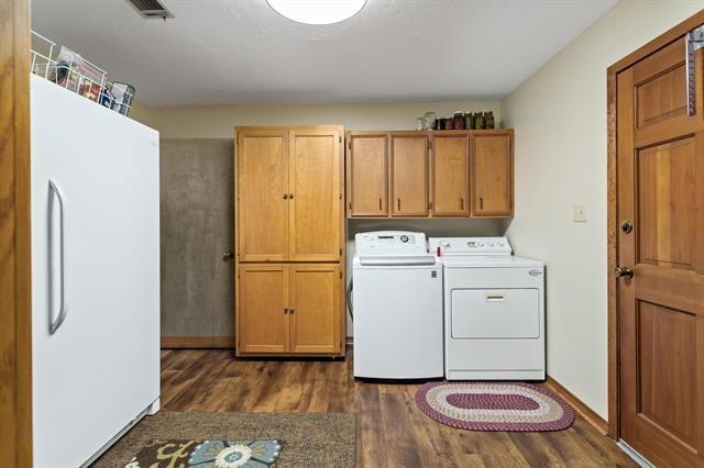 527 E Walton Rd, Lumberton, TX 77657 - laundry area with dark wood finished floors, separate washer and dryer, and cabinet space
