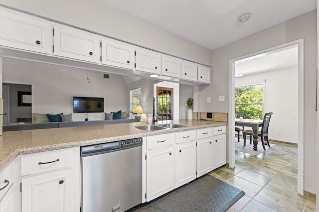 211 4th St, Dickinson, TX 77539 - kitchen with stainless steel dishwasher, a sink, white cabinetry, light countertops, and light tile patterned flooring
